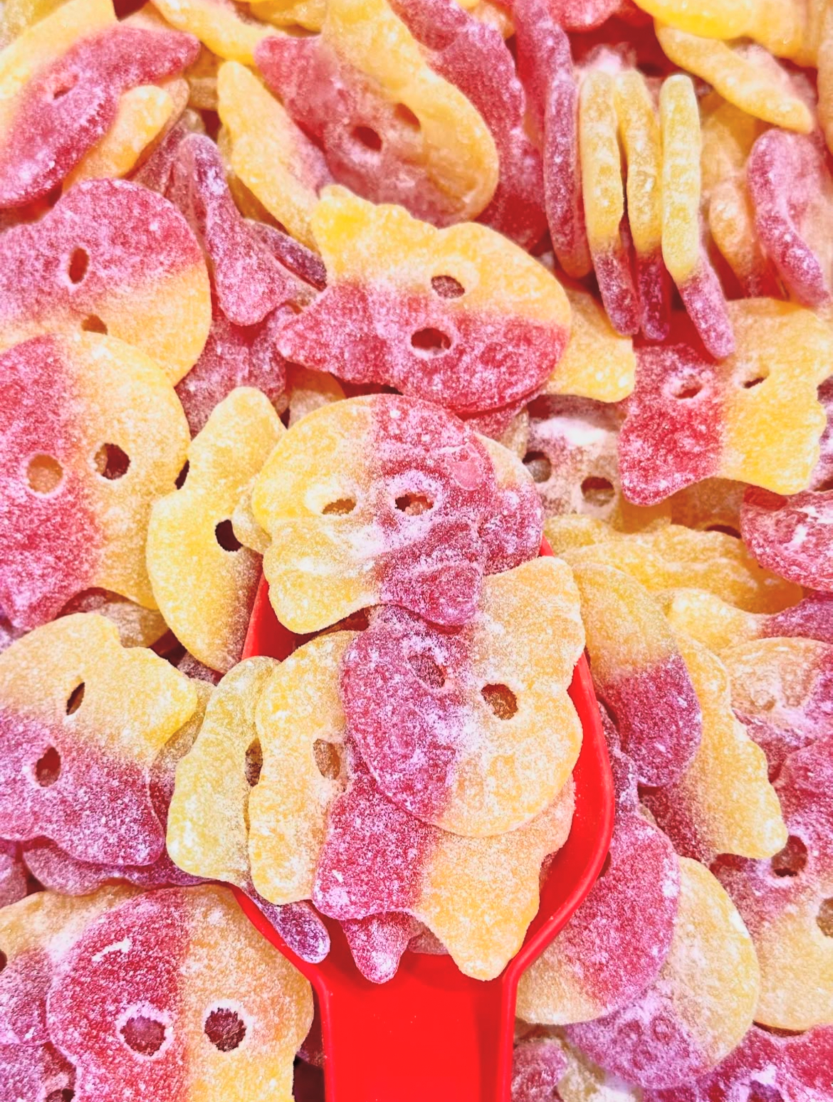 Sura dödskallegodisar i gult och rött med röd godisskopa